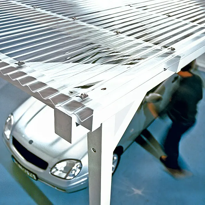 PLEXIGLAS® Wellplatte Resist - 200 cm x 104,5 cm x 1,8 mm, Acrylglas (PMMA), Transparent, Glatt, 76/18 mm, Rund - Ein Carport mit lichtdurchlässigem Dach schützt ein silbernes Auto. Das Design ist modern und funktional.