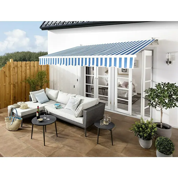 Sichtschutzelement Starnberg - 90 x 100/180 cm, Abgeschrägt, Herbstgold - Die elegante Markise mit blau-weißen Streifen spendet Schatten auf der Terrasse mit stilvollen Gartenmöbeln.