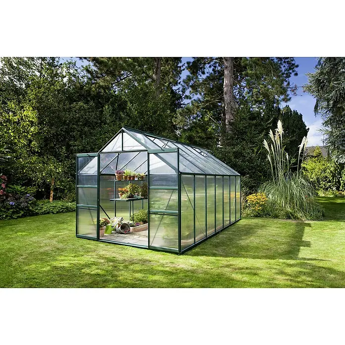 Vitavia Gewächshaus Mars 11500 Plus - Außenmaß inkl. Dachüberstand (B x T): 257 x 445 cm, 4 mm, Smaragd - Das Bild zeigt ein Gewächshaus mit Pflanzenregalen im Garten, umgeben von üppigem Grün und Bäumen.