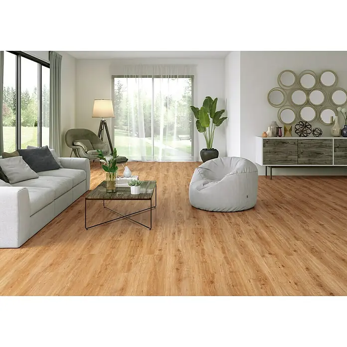 LOGOCLIC Laminado Roble Miel - 1.200 x 196 x 10 mm, Roble Miel, AC5 - Esta imagen muestra una habitación luminosa con un suelo de madera que crea un ambiente cálido. Un sofá blanco y un puf invitan a quedarse.
