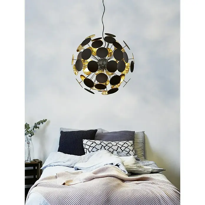 Reality Leuchten Pendelleuchte rund Discalgo - 40 W, Ø x H: 54 x 150 cm, Schwarz, Gold, E14 - Moderne Hängeleuchte mit kreisförmigen Elementen in Schwarz und Gold über einem gemütlichen Bett mit Kissen und Decken.