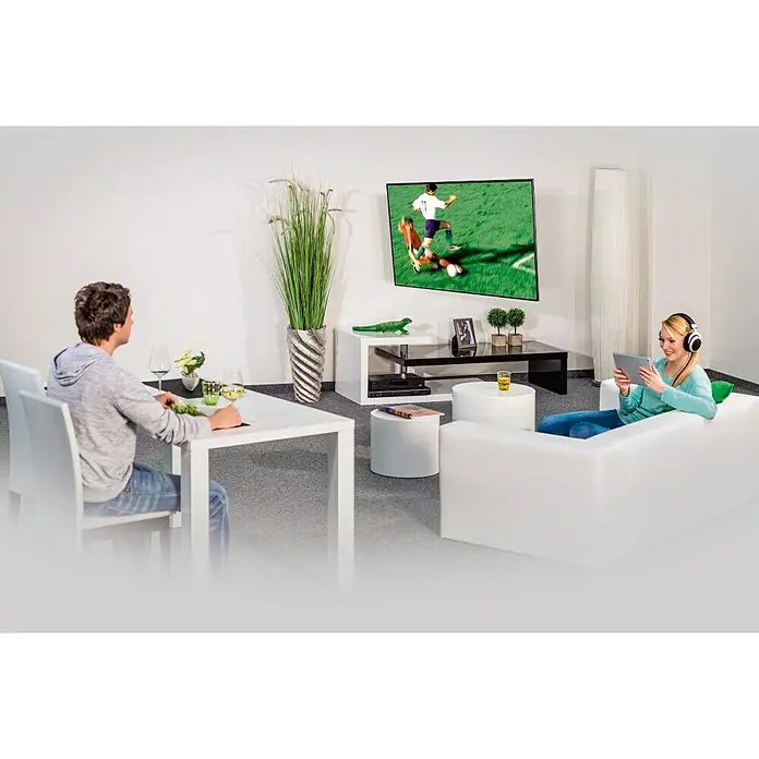Soporte para televisor Giratorio - Televisores 37 - 65' pulgadas, 35 kg - Salón con sofá blanco, mesa y TV, donde se juega un partido de fútbol. Una mujer se relaja con una tableta.