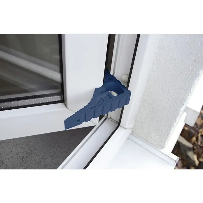 Schellenberg Tür- & Fensterstopper - Dunkelblau - Bild eines blauen Fensterstopper-Keils, der zwischen Fenster und Rahmen platziert ist, um die Belüftung zu ermöglichen.