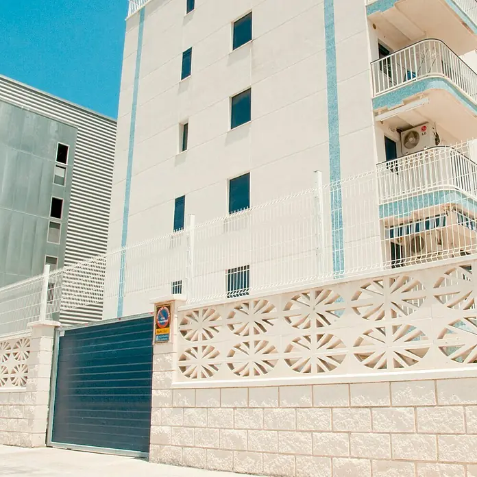 Celosía de pared Abanico - 40 x 20 cm, Blanco - El moderno edificio cuenta con una fachada blanca y detalles azules que realzan el diseño y el atractivo visual.