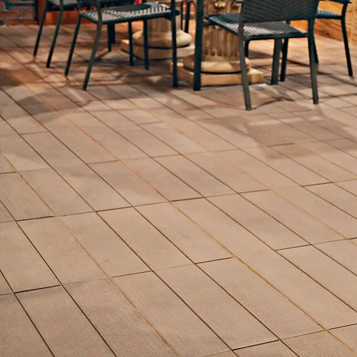 Pavimento para exterior Ipe Nogal - 57 x 44 cm, Marrón - Primer plano de baldosas marrones para terrazas de madera bajo una mesa y sillas con estructura metálica.