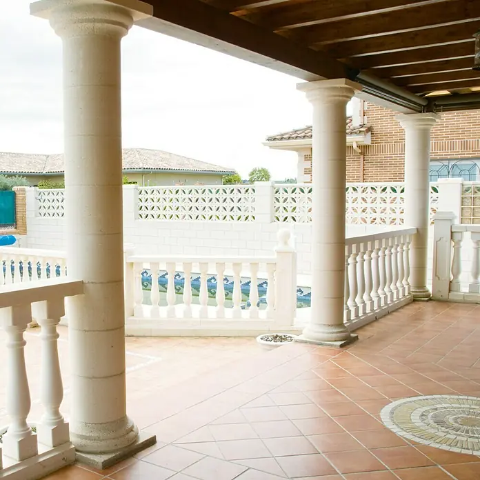 Base para techo o suelo Capitel Atenas - 40 x 40 cm - Zona exterior con suelo de baldosas, columnas, muros de ladrillo blanco y balaustradas decorativas que ofrecen una elegante transición a la piscina.