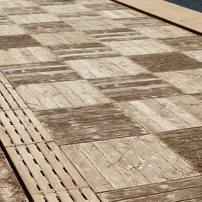 Pavimento para exterior Madera Nogal - 50 x 50 cm, Marrón - Primer plano de un paseo marítimo de madera con patrones cuadrados, mostrando una estética rústica y natural.