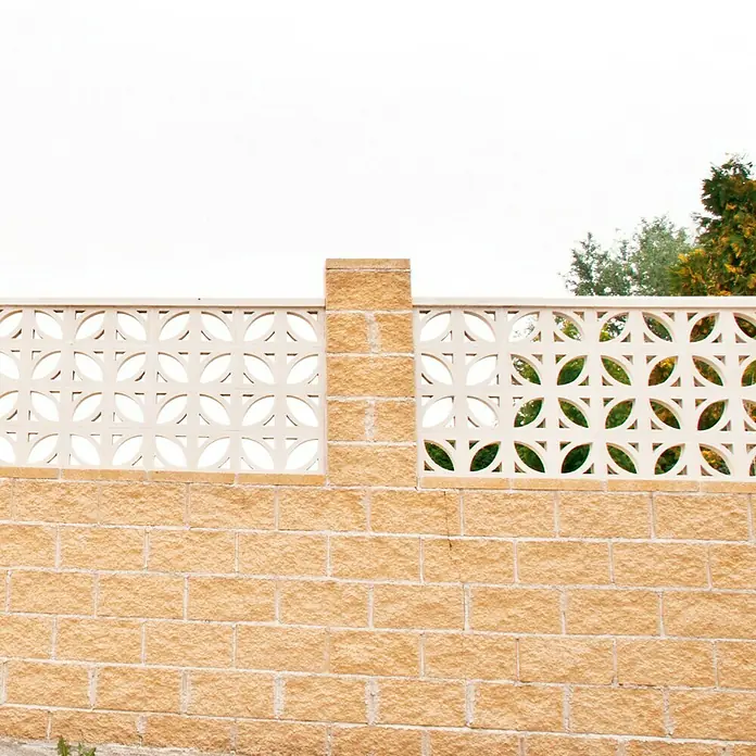 Celosía de pared Pétalos - 40 x 20 cm, Blanco - Muro de jardín decorativo hecho de ladrillos beige y elementos decorativos de hormigón blanco con un patrón circular bajo un cielo brillante.