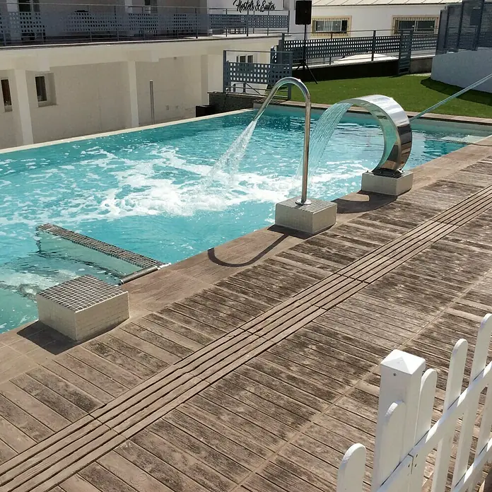 Pavimento para exterior Madera Nogal - 50 x 50 cm, Marrón - La refrescante piscina con juegos de agua invita a relajarse. ¡Disfruta del sol en la terraza de madera junto a la piscina!