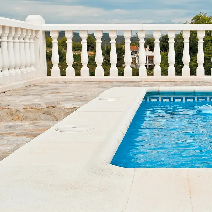 Pavimento remate Piscina R1 - 50 x 25 cm, Blanco - Piscina acogedora con azulejos de mosaico azul y borde blanco frente a una elegante balaustrada, que desprende un toque de estilo mediterráneo.