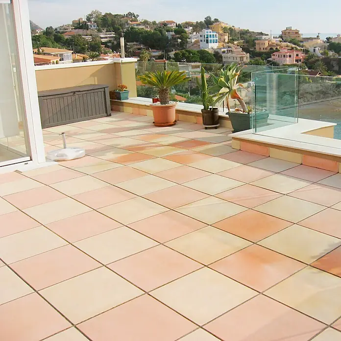 Pavimento para exterior Granulada - 50 x 50 cm, Salmone - Terraza con baldosas cuadradas en varios tonos terracota, creando un ambiente cálido y acogedor.
