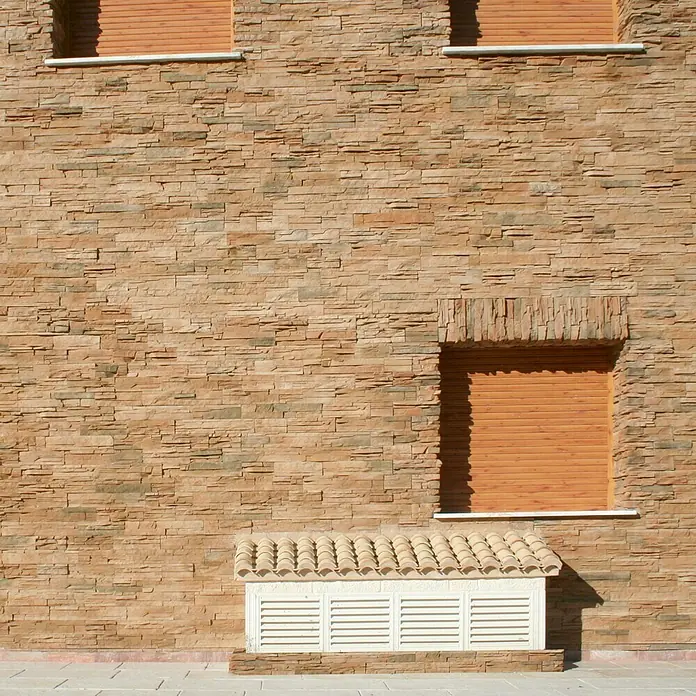 Estor plisado celular de ventilación - 40 x 40 cm, Blanco - Una fachada revestida de piedra con tres ventanas con persianas, ofreciendo un detalle de diseño arquitectónico.