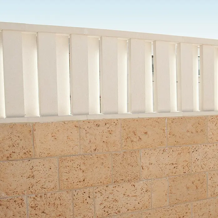 Pasamano de protección contra viento - Hormigón polímero, Largo: 50 mm - Primer plano de un muro decorativo con un elegante remate de valla blanco, que añade un toque moderno al diseño.
