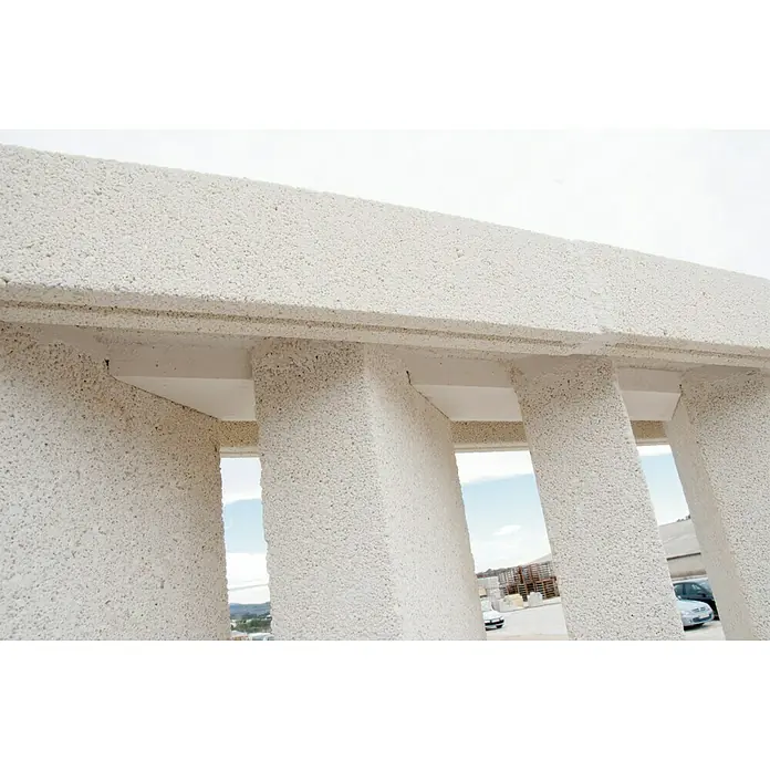 Tapa derecha de protección contra viento - Hormigón polímero, Blanco - Primer plano de una estructura de hormigón celular, destacando su textura y construcción únicas. El enfoque está en el material y la arquitectura.