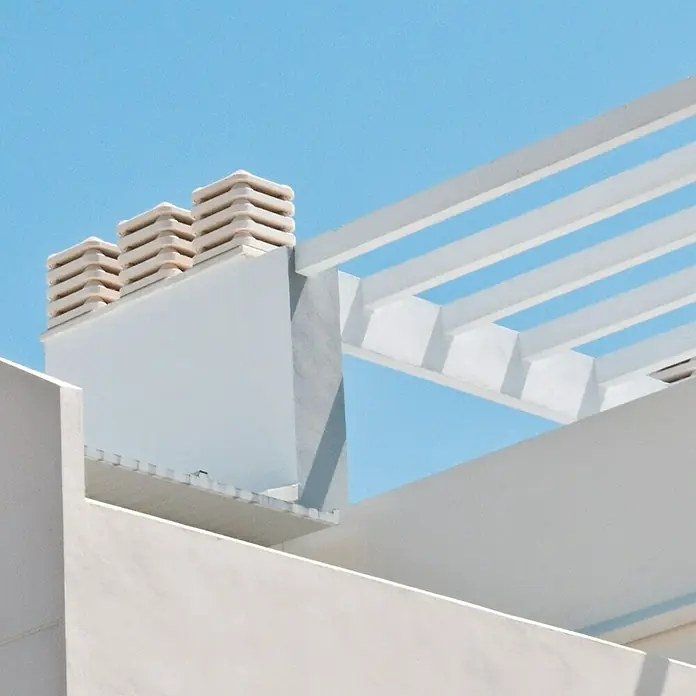 Aspirador estático 50 - Blanco - Detalles arquitectónicos brillantes contra un cielo azul claro. Enfoque en el diseño minimalista de la estructura del edificio.