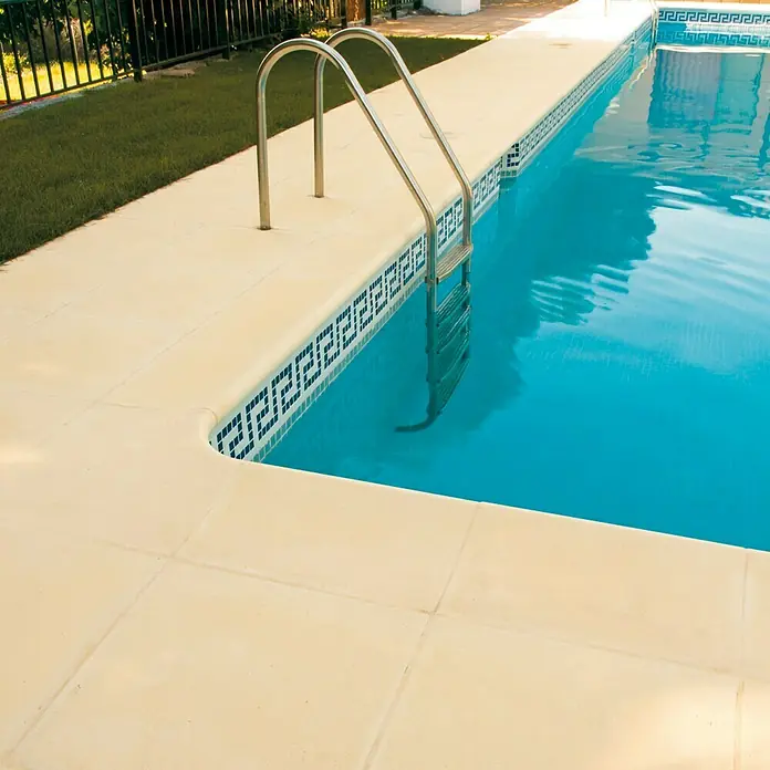 Pavimento remate Piscina - 50 x 34 cm, Crema - Escena de piscina con una escalera que conduce a aguas azules, rodeada de un borde de piscina de baldosas claras.