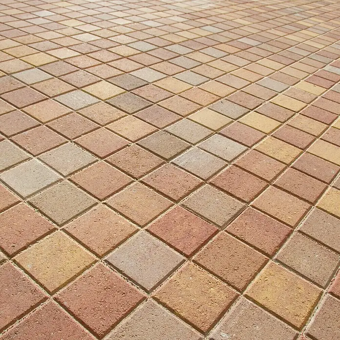 Loseta de exterior Irisada - 15 x 15 x 3,5 cm, Terracota, Hormigón - Primer plano de un suelo con adoquines cuadrados en varios tonos de rojo y amarillo, formando un patrón cálido y rústico.