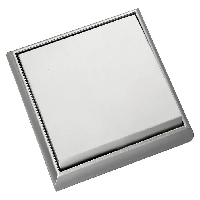 Fontini BF-25 Cruzamiento Monoblock - Aluminio, Montaje en superficie - Primer plano de un desagüe de piso cuadrado de metal empotrado con una superficie lisa y blanca, con un diseño elegante y moderno.