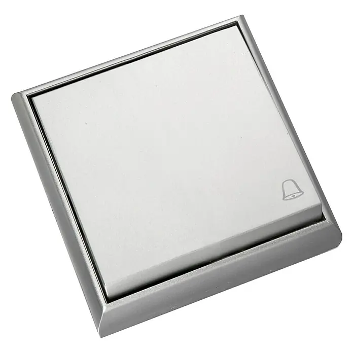 Fontini BF-25 Pulsador para estancias con humedad Monoblock - Aluminio, Montaje en superficie - Primer plano de un timbre plateado con un símbolo de campana sobre un fondo negro, ideal para entradas y diseños modernos.