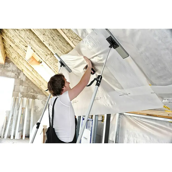 Schnellspann Deckenstützen & Türspanner Spannaufsatz XXL - 400 x 80 mm - Mann montiert Folie an der Decke mit einem flexiblen Deckenstützensystem für sicheren Halt.