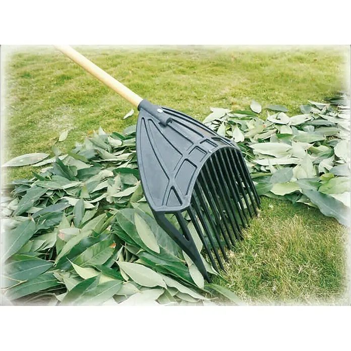 Freund Victoria Laubschaufel 3 in 1 - Anzahl Zinken: 14 - Laubrächen aus Kunststoff mit Holzgriff auf einem Rasen mit Laub. Die Rätsche ist ideal für die Gartenarbeit und das Entfernen von Blättern.