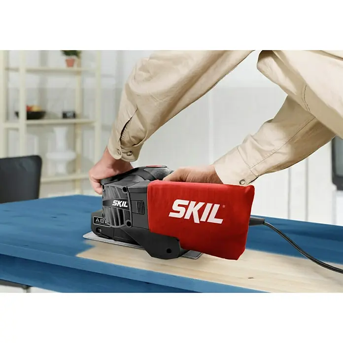 Skil Elektro-Bandschleifmaschine 1210 AA - 650 W - Nahaufnahme des SKIL Handschleifers in Aktion, ideal zum Glätten von Oberflächen.