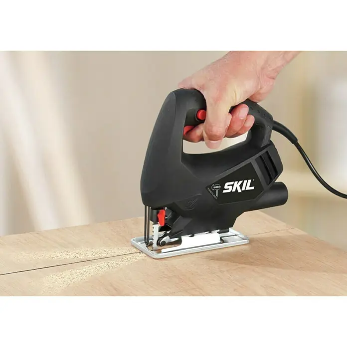 Skil Elektro-Stichsäge 4190 AA - 3.100 /min, 65 mm - Nahaufnahme einer SKIL Stichsäge, die durch ein Holzbrett schneidet, wobei der Fokus auf der Präzision und Leistung des Werkzeugs liegt.
