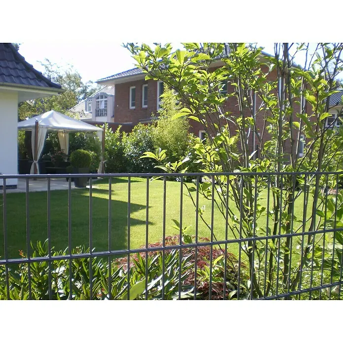 Peddy Shield Zaun-Set DSM - 2 x 1,23 m, Anthrazit, 11 -tlg. - Ein Gartenzaun aus Drahtgeflecht mit üppigem Grün im Hintergrund bietet eine robuste und stilvolle Begrenzung für den Garten.
