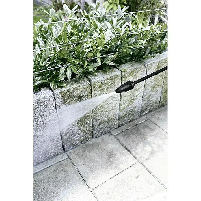 Kärcher Hidrolimpiadora de alta presión K 2 Universal Edition - 110 bar, 1.400 W, Capacidad de bombeo: 360 l/h - Una hidrolavadora que se utiliza para limpiar un camino de piedra. El chorro de agua a alta presión está eliminando la suciedad.