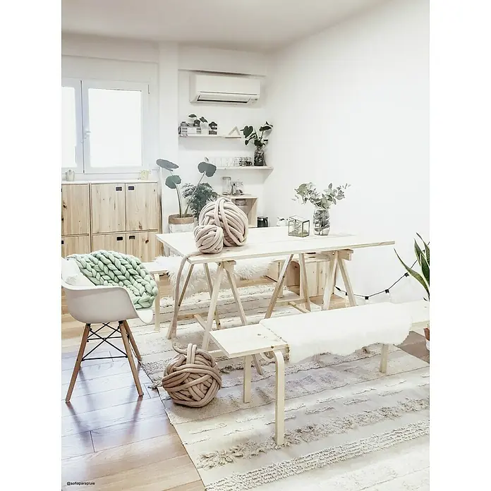 Astigarraga Holzbock Deco - Tragkraft: 400 kg, Höhe: 72 cm, Kiefer, Natur - Ein helles Interieur mit einem Tisch und Bänken aus hellem Holz, dekoriert mit grober Strickwolle. Ein mintgrüner Überwurf ziert einen Stuhl.