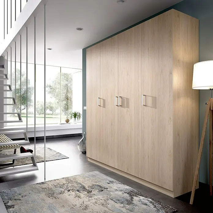 Dekit Armario para ropa Maxi - L x An x Al: 52 x 200 x 215 cm, Roble, Número de puertas: 4 ud. - La imagen muestra un amplio armario de madera clara en una habitación moderna con escalera y una gran ventana.