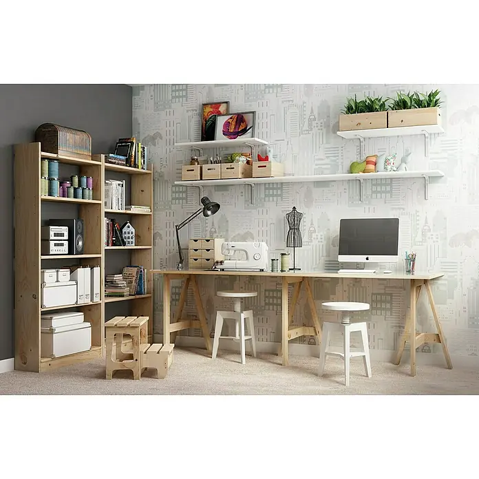 Astigarraga Caballete de madera Glam - Peso máximo admitido: 400 kg, Altura: 74 cm, Pino, Natural - Una habitación luminosa con una gran librería de madera y un escritorio largo que sirve como área de trabajo y de costura. Dos taburetes blancos complementan el espacio.