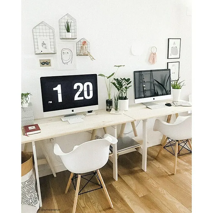 Astigarraga Caballete de madera Glam - Peso máximo admitido: 400 kg, Altura: 74 cm, Pino, Natural - Un espacio de trabajo luminoso con dos ordenadores iMac sobre una mesa de madera, complementado con decoración minimalista y sillas blancas.