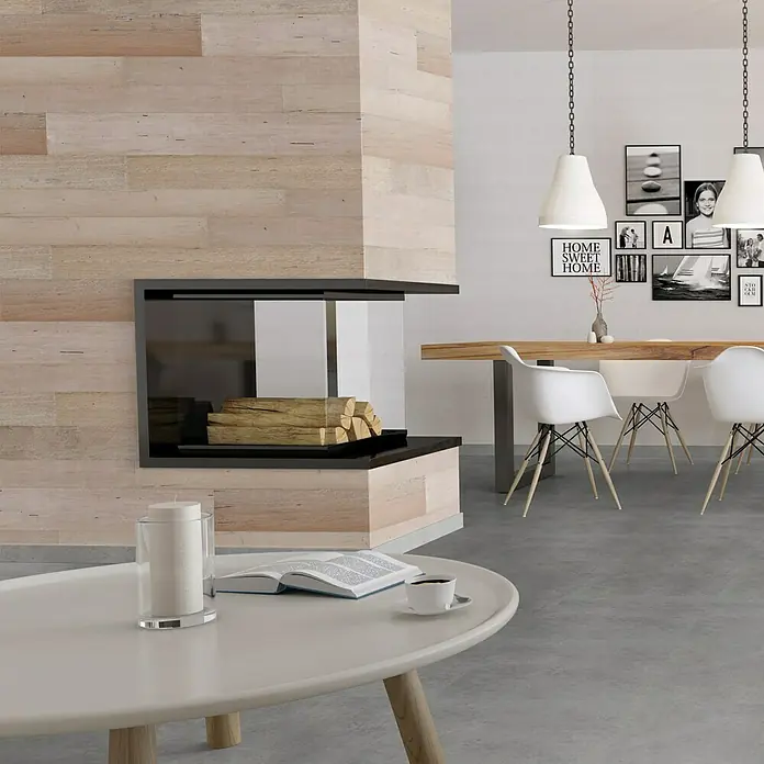 Indo Wandpaneel Barnwall Tuscany - Shorea, 1.200 x 120 x 10 mm, 0,864 m² - Ein moderner Wohnbereich mit einem stilvollen Kamin, einem weißen Couchtisch mit Buch und einer Tasse Kaffee. Die Hängeleuchten runden das Bild ab.