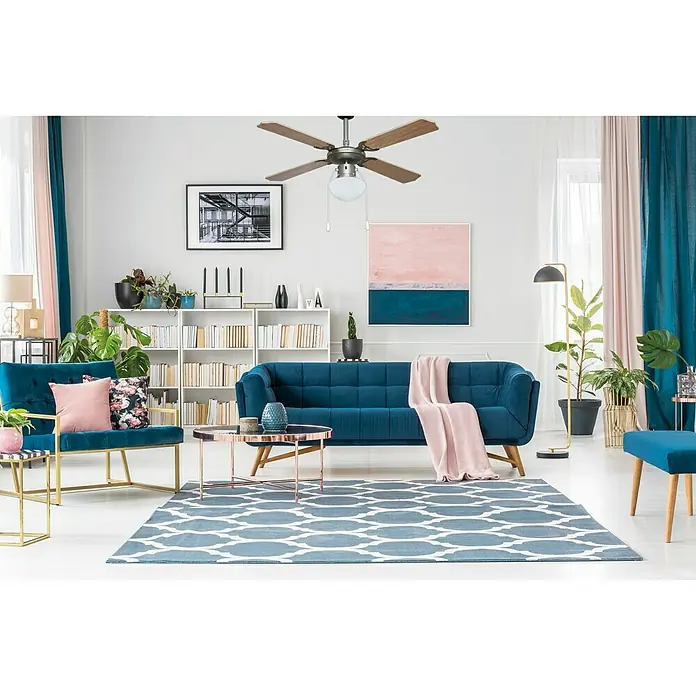 Arte confort Ventilador de techo Hawai - Haya, 107 cm, 55 W - Un salón moderno con un sofá de terciopelo azul, sillones y un ventilador de techo, creando un ambiente elegante y confortable.