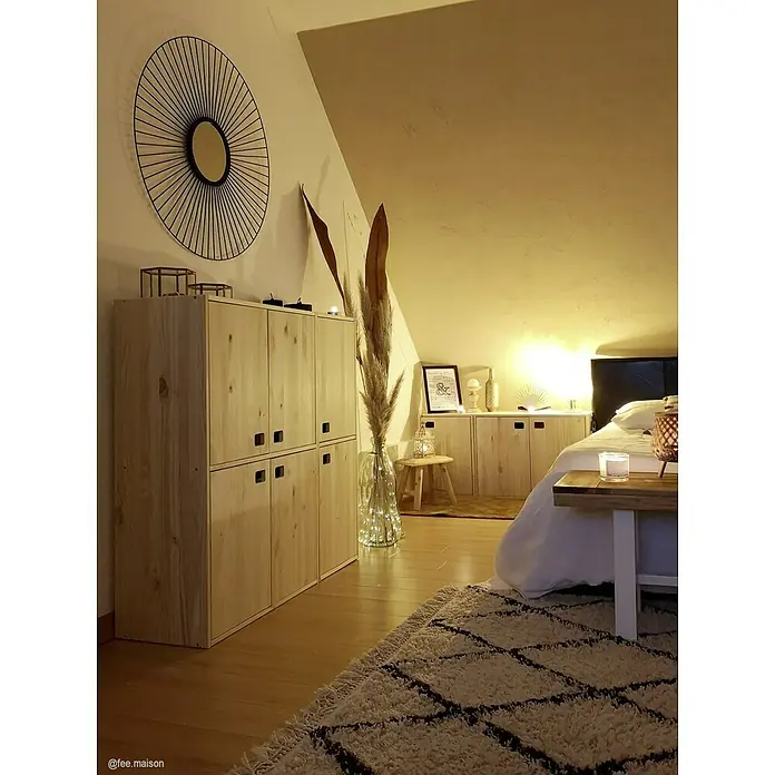 Astigarraga Dinamic Schrank - L x B x H: 33 x 37,3 x 53,5 cm, Kiefernholz - Gemütliches Schlafzimmer mit hellem Holzschrank, Spiegel und Teppich. Warme Beleuchtung sorgt für eine entspannte Atmosphäre im Raum.