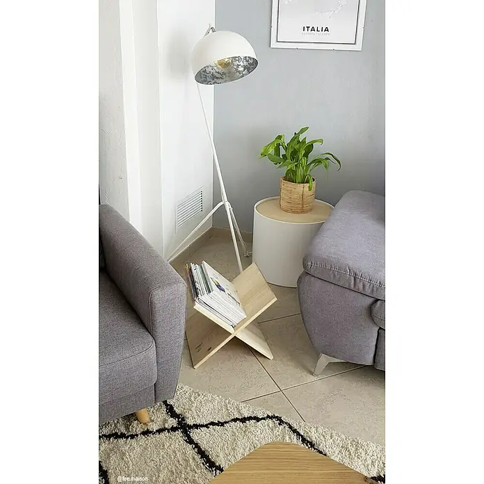 Astigarraga Dinamic Weinregal - L x B x H: 33 x 32,5 x 32,5 cm, Holz - Eine Stehlampe mit einem Lampenschirm in Weiß- und Silberfarben, neben einem hölzernen Zeitschriftenständer und einem Beistelltisch mit einer grünen Pflanze.