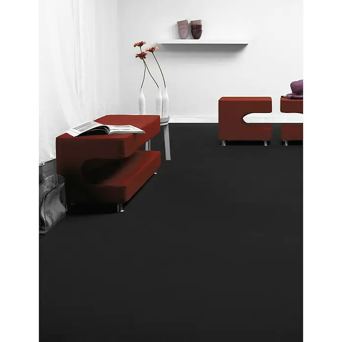 Teppichboden Meterware Silvia - Breite: 400 cm, Nadelfilz, 100 % Polypropylen, Schwarz - Innenaufnahme eines Raumes mit einem modularen, roten Sitzbereich, der mit weißen Akzenten und dunklem Boden für ein modernes Ambiente sorgt.