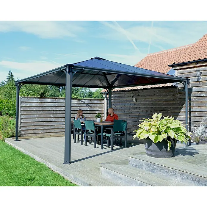 Palram – Canopia Pérgola estándar Martinique - An x Pr: 429 x 429 cm, Color del armazón: Antracita, Aluminio - Una elegante pérgola de jardín con mesa y sillas, perfecta para relajarse al aire libre y celebrar reuniones sociales.