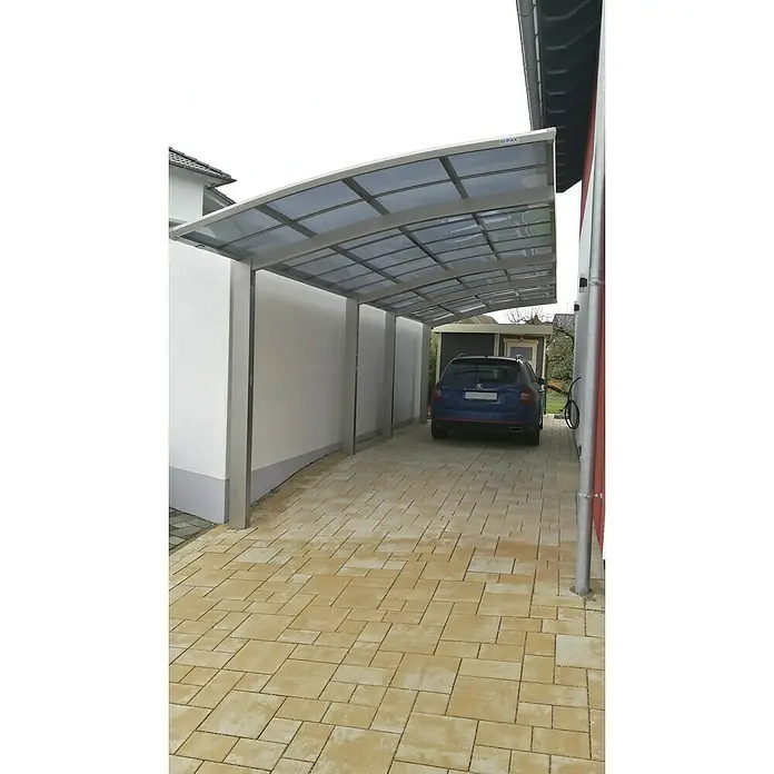 Ximax Carport Portoforte Tandem 80 - Außenmaß inkl. Dachüberstand (B x T): 2,7 x 9,83 m, Doppelcarport, Edelstahloptik, Schneelast: 100 kg/m² - Das Bild zeigt einen modernen, freistehenden Carport mit grauem Dach und silbernen Stützen, der Schutz für das darunter geparkte Auto bietet.