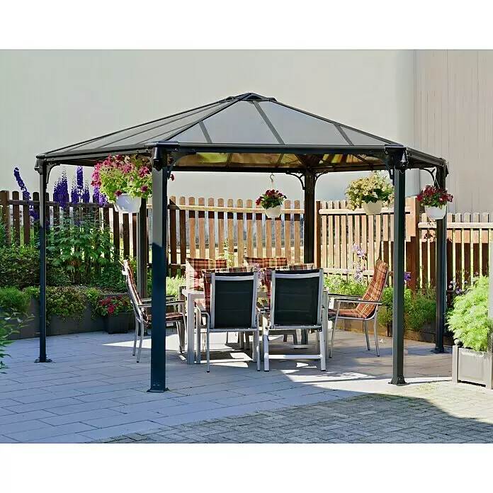 Palram – Canopia Pérgola estándar Mónaco - An x Pr: 390 x 450 cm, Color del armazón: Antracita, Aluminio - Cenador hexagonal gris oscuro con paneles de techo translúcidos, que alberga un comedor exterior en un patio.