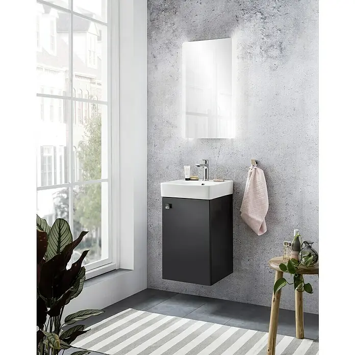 Camargue Visita LED-Lichtspiegel - 44 x 74 cm - Modernes Badezimmer-Interieur mit einem stilvollen Waschbeckenunterschrank in Schwarz und einem beleuchteten Spiegelschrank an einer grauen Wand.