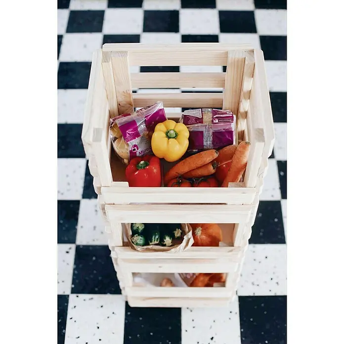Astigarraga Evolution Carro de cocina - L x An x Al: 30 x 38 x 90 cm, Natural - Un estante de madera lleno de verduras frescas como pimientos, tomates y zanahorias, junto con pasta, sobre un suelo de cuadros blancos y negros.