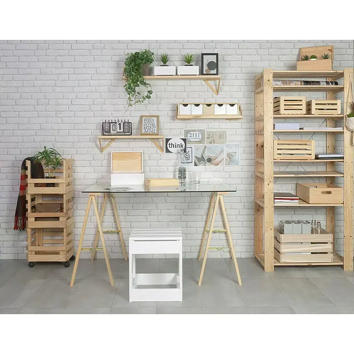 Astigarraga Caballete plegable de madera Kipli - Peso máximo admitido: 250 kg, Altura: 73,5 cm, Pino - Disposición de muebles con estanterías, un escritorio con tapa de cristal y un taburete blanco frente a una pared de ladrillos blancos, creando un ambiente elegante.