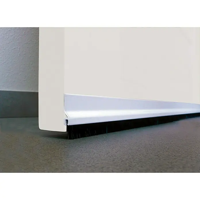 Junta para puerta aluminio - Blanco, Largo: 92 cm - Primer plano de un burlete con cepillo instalado en una puerta blanca, diseñado para bloquear corrientes de aire y sellar espacios.