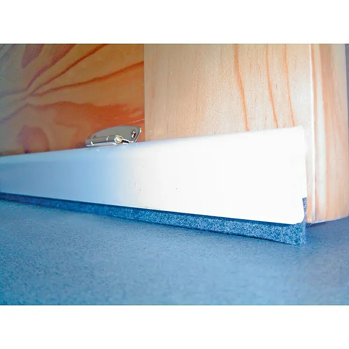Burlete para puerta Basculante - Blanco - Primer plano de un burlete blanco con cepillo en una puerta de madera, creando una barrera contra corrientes y polvo.