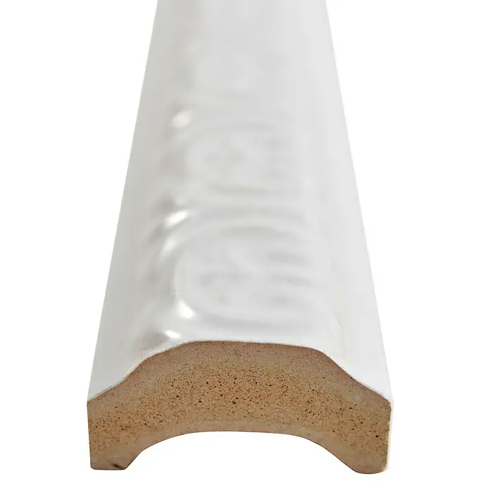 Fliesenbordüre Tuba - 3,5 x 30 cm, Weiß, Glänzend - Nahaufnahme einer weißen, verzierten Keramikfliese mit abgerundeten Kanten, die die Detailgenauigkeit und Materialbeschaffenheit hervorhebt.