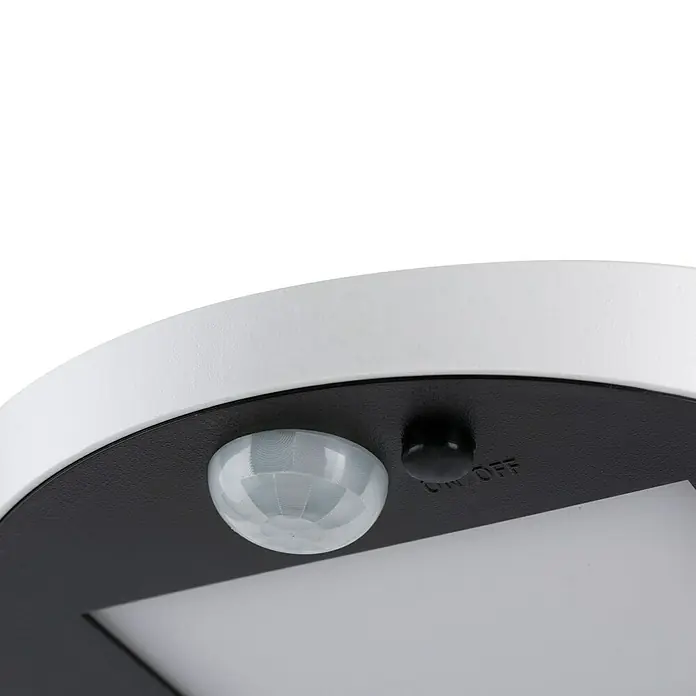 Paulmann Ryse Solar-Außenwandleuchte - 1,2 W, L x B x H: 14,7 x 15,4 x 4,1 mm, Weiß, IP44 - Nahaufnahme einer runden, weißen Lampe mit Bewegungssensor und Ein/Aus-Schalter auf einer schwarzen Oberfläche.