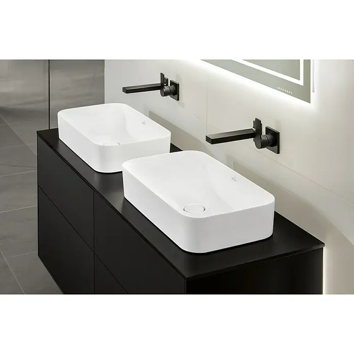 Villeroy & Boch Finion Aufsatzwaschbecken - 60 x 35 cm, Mit schmutzabweisender Glasur, Hahnloch: Ohne, Ohne Überlauf, Weiß - Zwei moderne, rechteckige Aufsatzwaschbecken aus weißer Keramik auf einem schwarzen Waschtisch mit minimalistischen Armaturen.