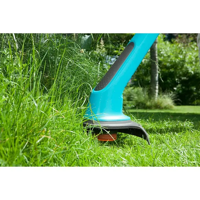 Gardena SmallCut Elektro-Rasentrimmer 350/23 Plus - 350 W, Schnittbreite Faden: 23 cm - Nahaufnahme eines blauen GARDENA Akku-Rasentrimmers im Einsatz, der Gras schneidet. Ideal für Gartenpflege und Rasenpflege.